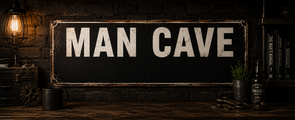Vintage style tin signs displayed in a dark industrial man cave setting with warm lighting, distressed workshop decor and rustic wooden surfaces.