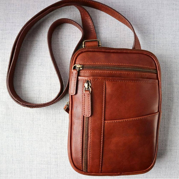 Brown leather crossbody bag on a light gray background