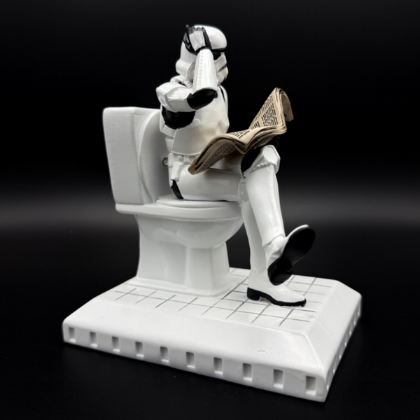 Officially licensed Stormtrooper Pooper Trooper figurine seated on a toilet reading a newspaper right side view