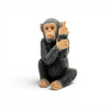 Small black resin monkey with middle finger on white background