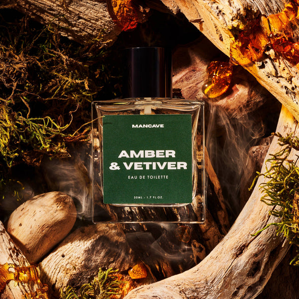 ManCave Amber & Vetiver Eau de Toilette 50ml displayed amongst natural wood and amber inspired elements.
