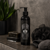 Dear Barber Body Wash 250ml in moody bathroom lifestyle setting with grooming accessories