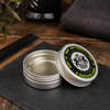 Dear Barber Strong Hold Pomade 20ml open styling pomade tin in a classic barber shop lifestyle scene with comb and grooming accessories