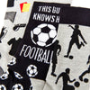 close up of football themed socks showing ball and player patterns