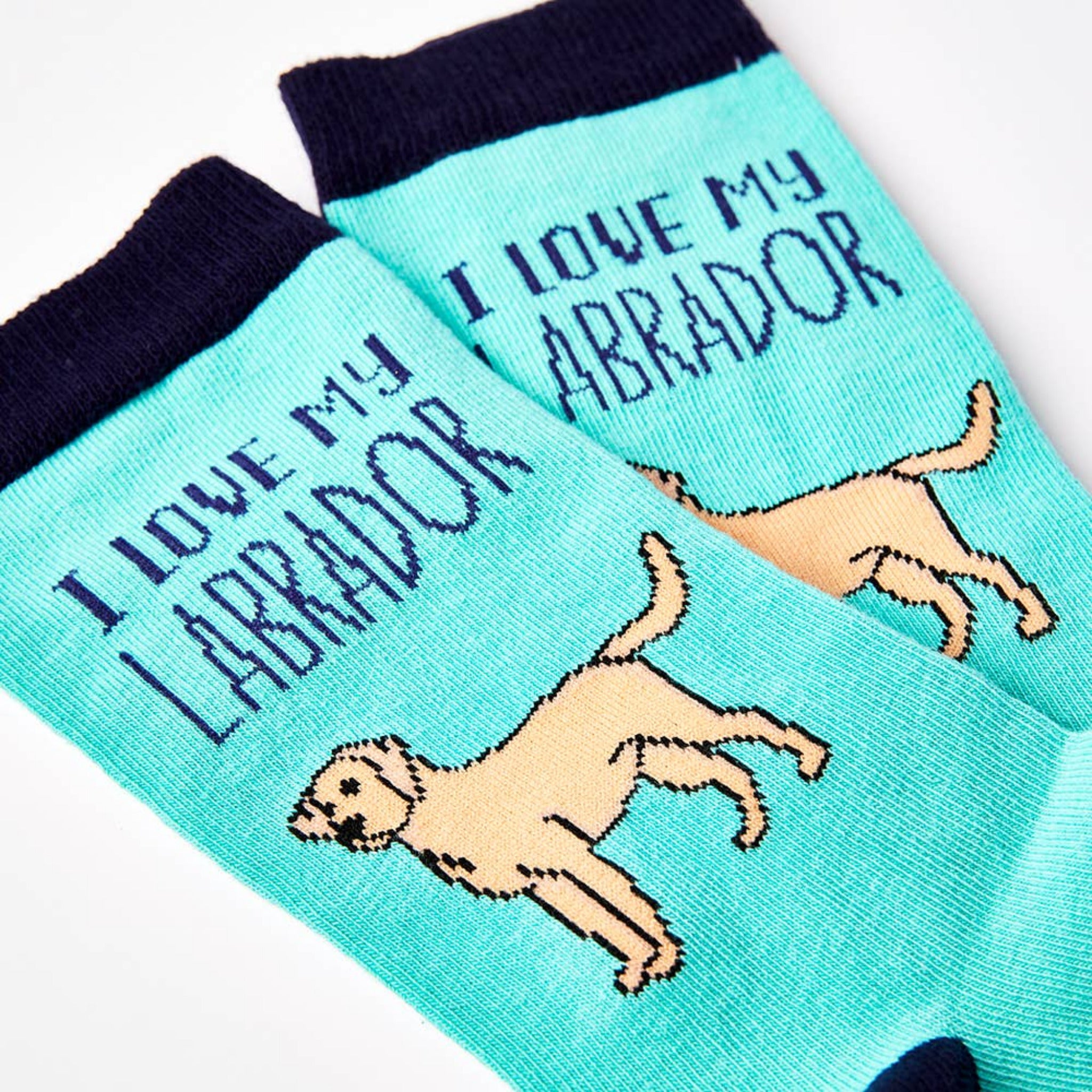 Pair of socks with 'I love my Labrador' text and dog illustrations on a light blue background.