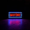 Man Cave neon sign glowing in a dark room with blue and red lighting