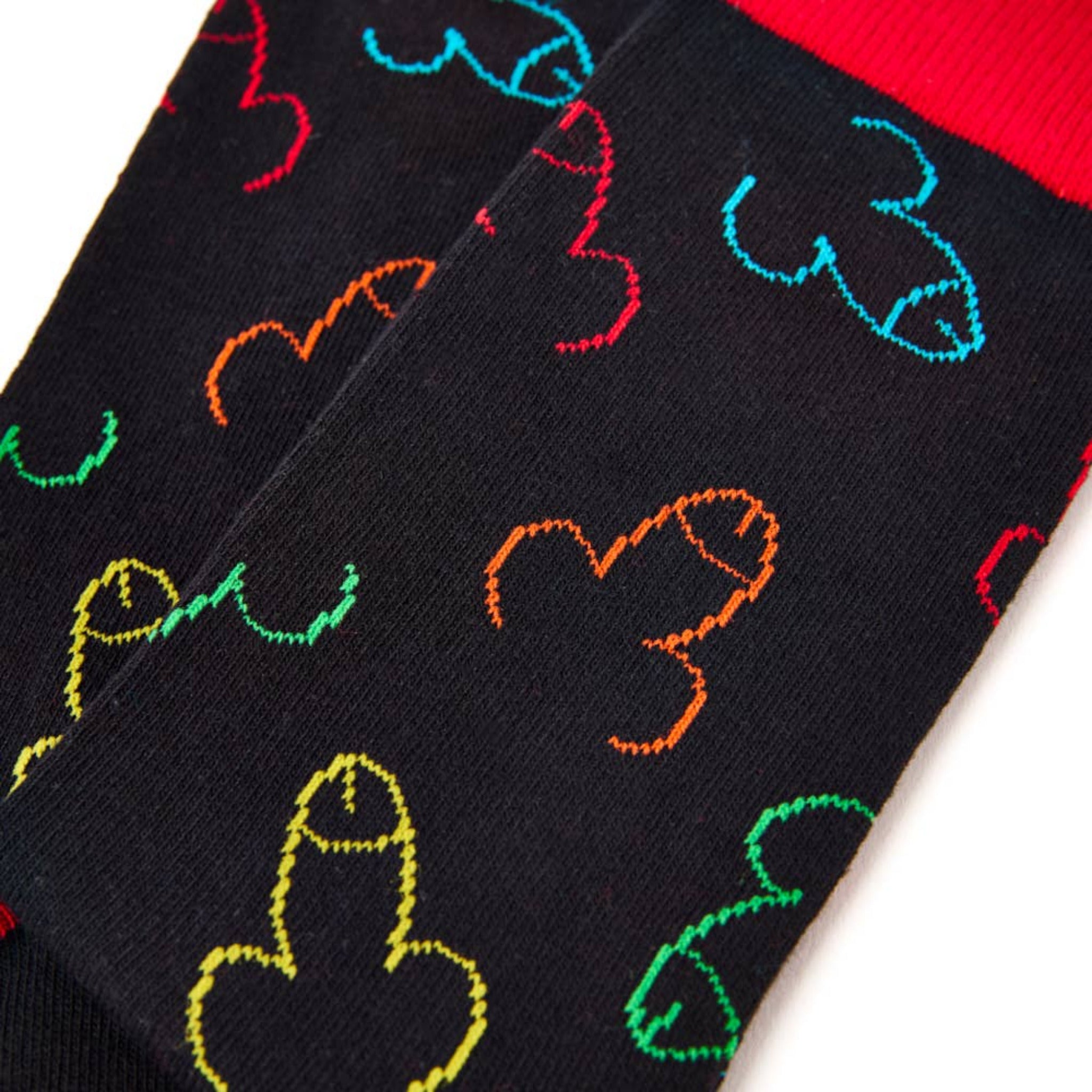 Close up of colourful novelty pattern on black socks with red trim