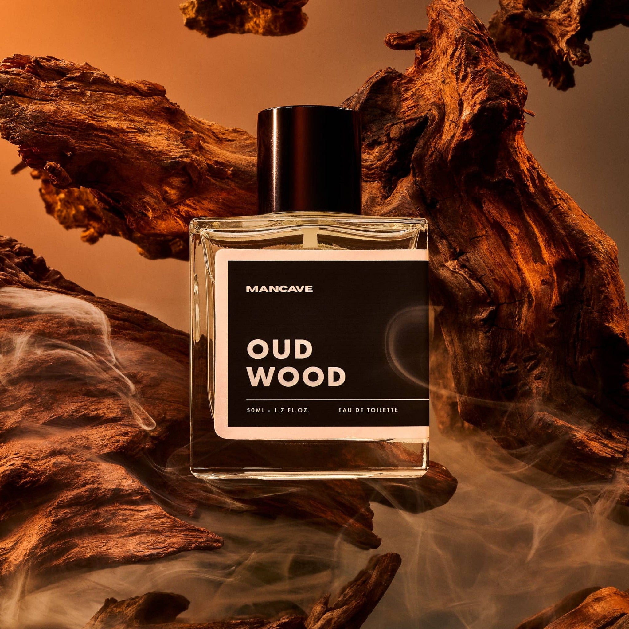 Man Cave Oud Wood Fragrance Spray 50ml displayed with natural oud wood, highlighting the rich woody character of the fragrance.