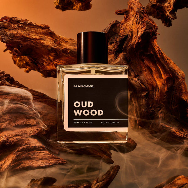 Man Cave Oud Wood Fragrance Spray 50ml displayed with natural oud wood, highlighting the rich woody character of the fragrance.