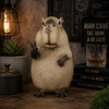Statue of a capybara making a peace sign in a cozy room with books and a lamp.