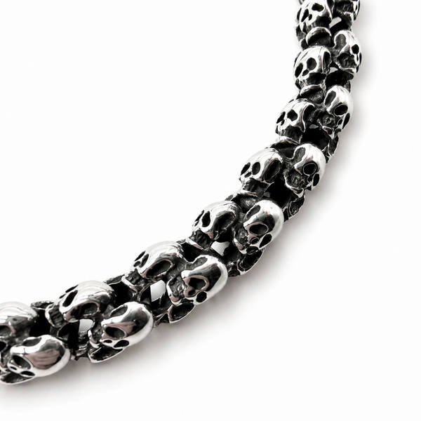 Close up of polished stainless steel skull links with dark detailing