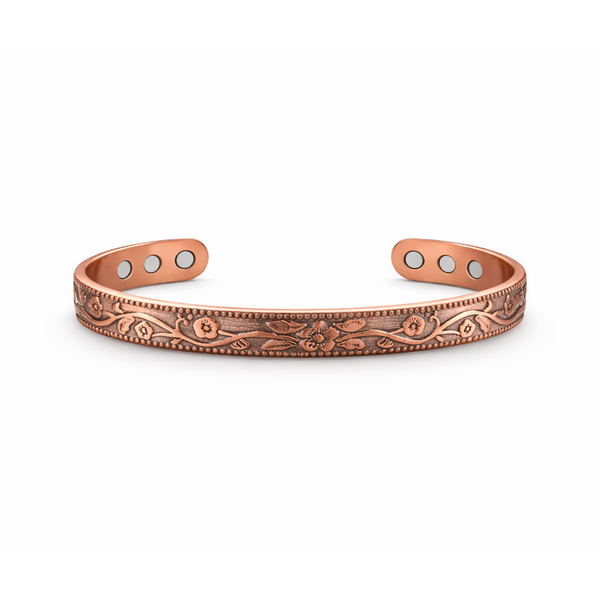Slim copper magnetic cuff bracelet with raised flower pattern on white background