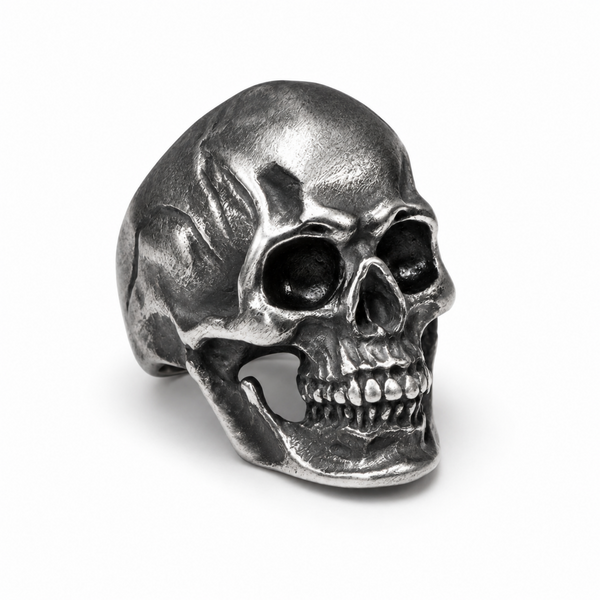 Front view of a stainless steel skull ring with a detailed vintage finish on a white background.