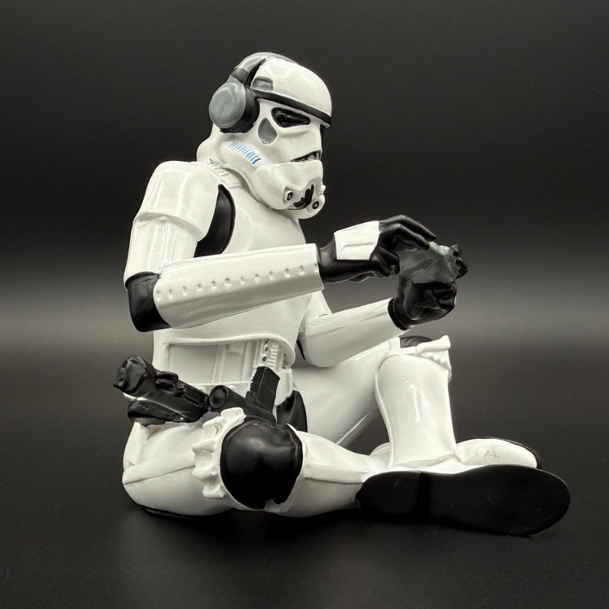 Officially licensed Stormtrooper gamer figurine right side view showing seated gaming pose with headset and controller