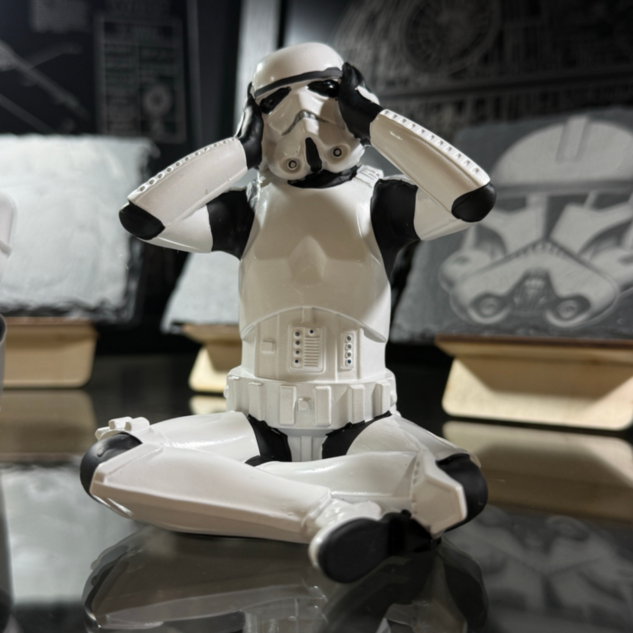 Stormtrooper hear no evil figurine 10cm sitting with hands covering ears displayed in shop cabinet