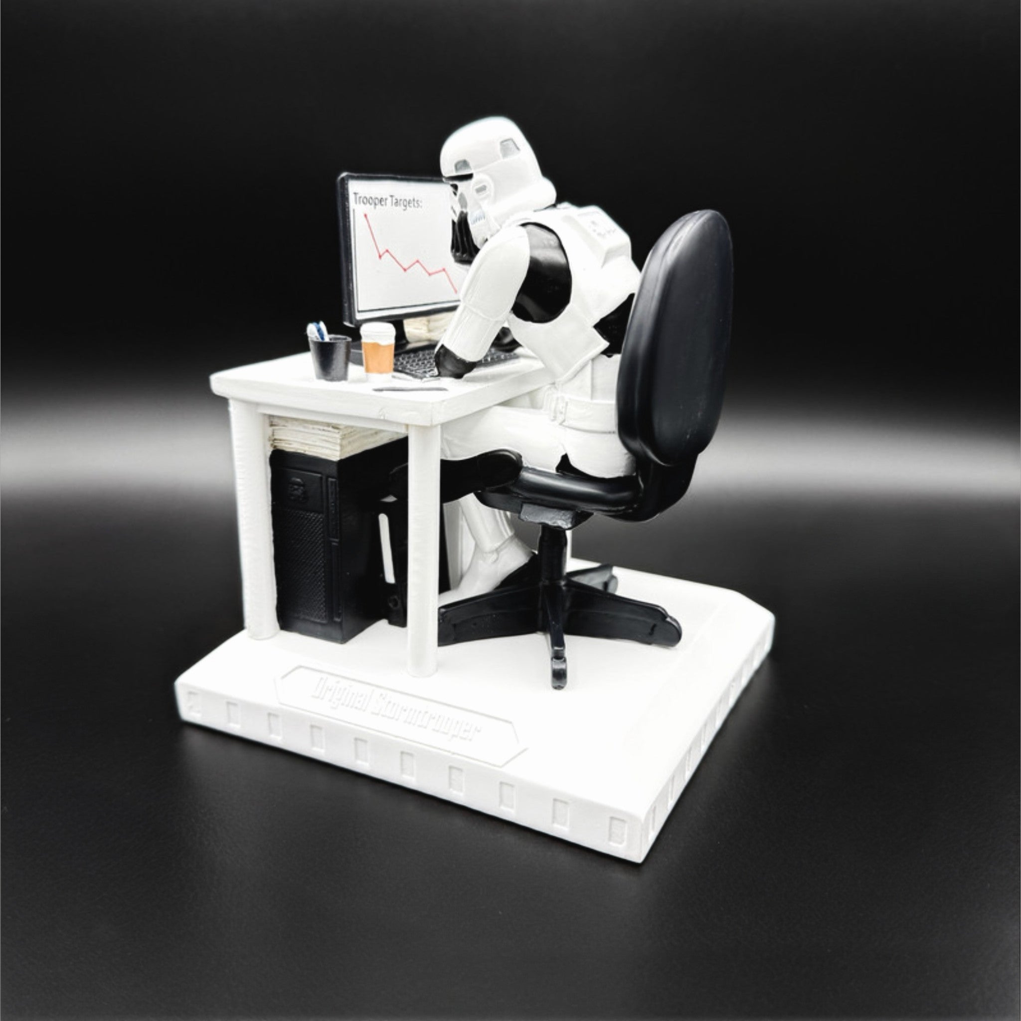 Original Stormtrooper Slave to the Wage figurine rear view showing a Stormtrooper at a desk with computer, coffee cup and declining target chart on screen
