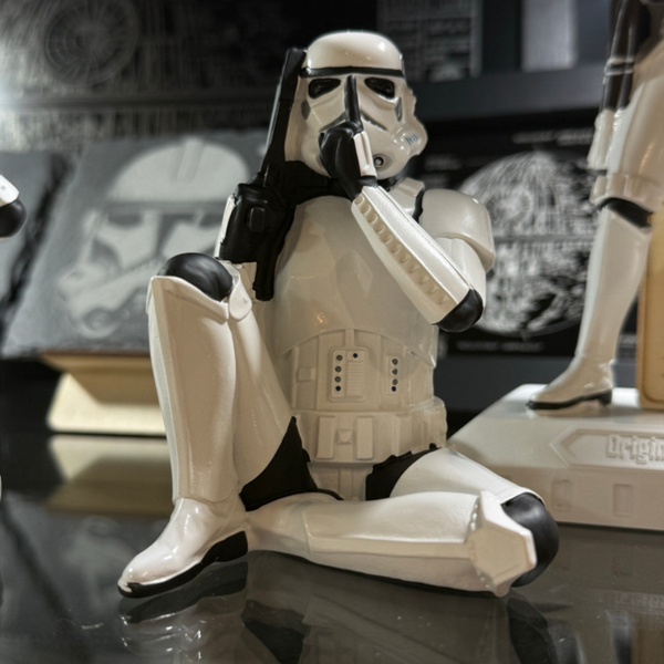 Stormtrooper speak no evil sitting figure 10cm hands covering ears lifestyle display with Star Wars themed background