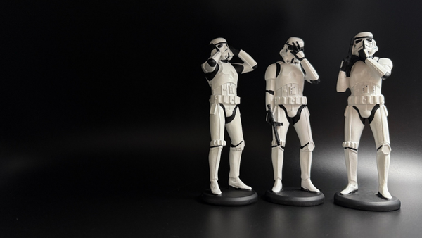 Three wise stormtrooper figures covering eyes ears and mouth on black background collectible display