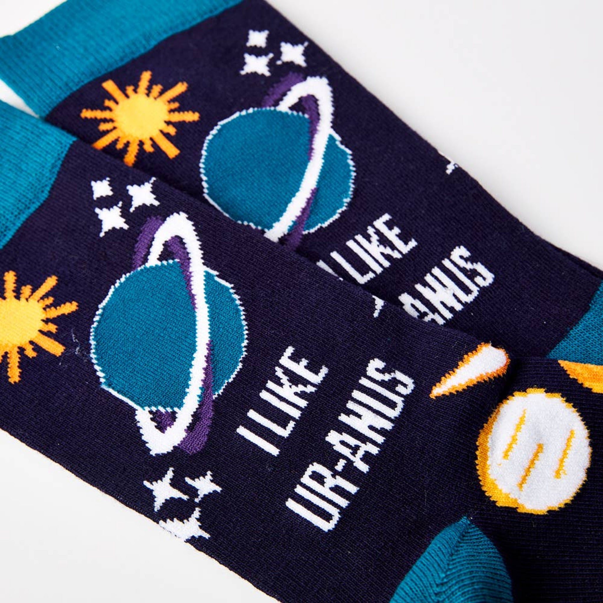 close up of I Like Ur-anus socks showing planet design and text