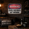 Warning Evil Genius At Work metal tin sign mounted on a dark industrial style man cave wall