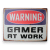 Warning Gamer At Work metal tin sign with distressed vintage styling on a plain white background